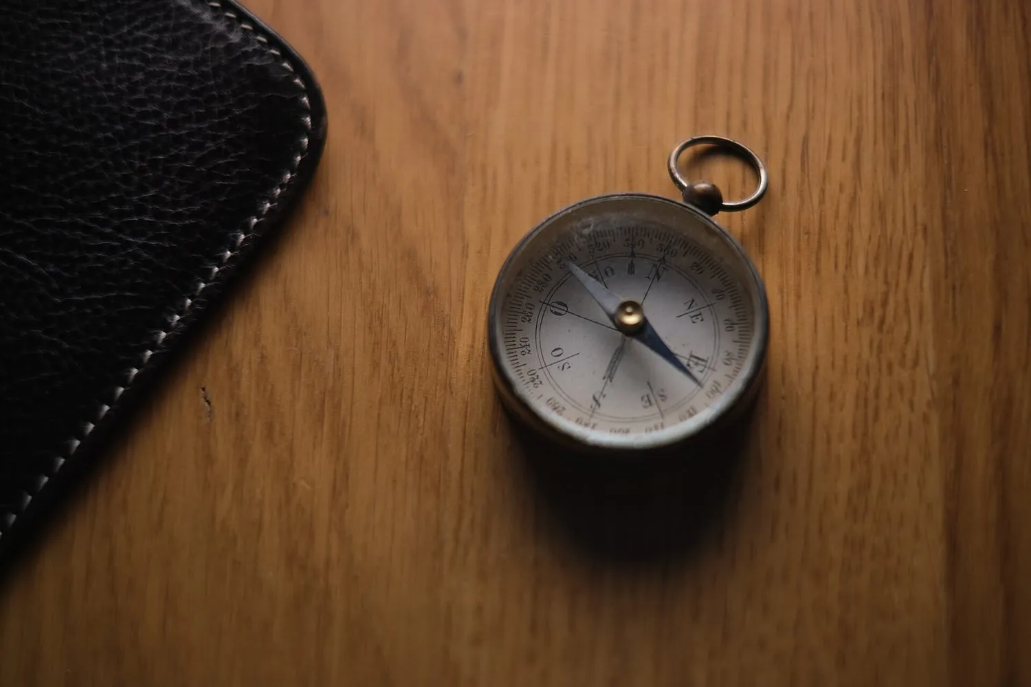 A magnetic compass lying on a wooden table